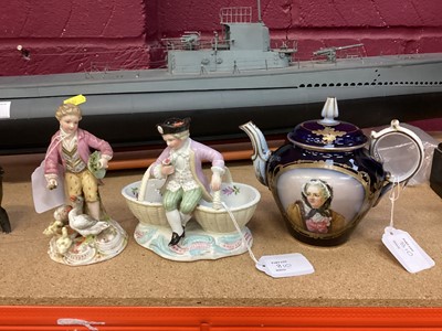 Lot 810 - German porcelain seated young boy between two baskets, together with Sèvres tea pot and lid (chip to base of handle), together with porcelain figure, young man feeding geese