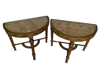 Lot 1387 - Pair of late 19th / early 20th century gilt demi-lune side tables, utilising early fabric panels.