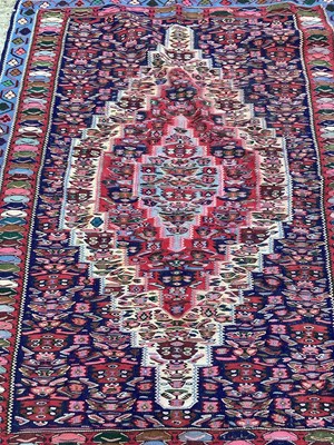 Lot 1453 - Eastern rug with geometric decoration on red and blue ground, 152cm x 120cm