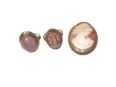 Lot 9 - 14ct gold rose quartz cabochon ring in a floral scroll engraved mount, together with a 9ct gold carved shell cameo ring and brooch (3)