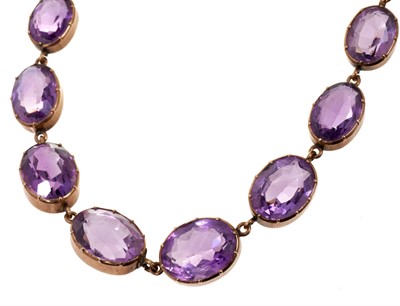 Lot 470 - Victorian amethyst and gold rivière necklace with graduated oval mixed cut amethysts in gold collet setting
