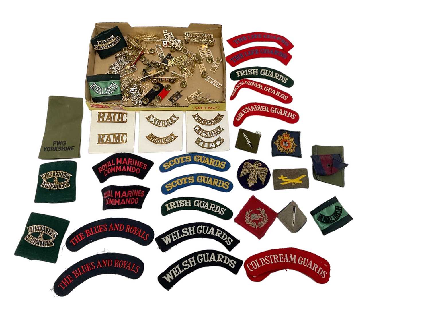 Lot 780 - Collection of British military shoulder badges / titles, in cloth and staybrite (1 box).