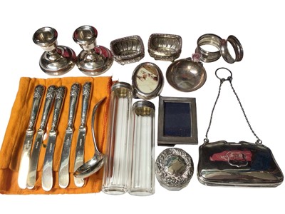 Lot 158 - Group of silver items including pair of salts, pair of candlesticks, silver topped glass jars, miniature photograph frames, napkin rings, pin dish, small ladle, antique purse and five silver handle...