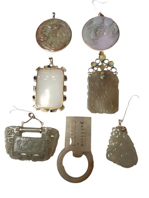 Lot 169 - Seven Chinese jade/ hard stone carved pendants and panels, some in 14ct gold and yellow metal mounts