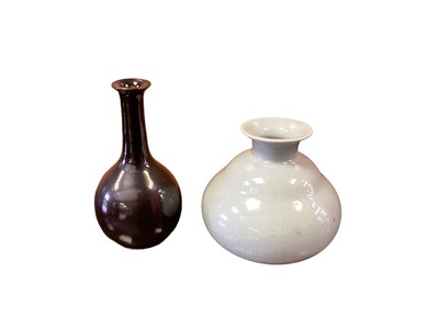Lot 1281 - Yeap Poh Chap (1927-2007) two porcelain vases - one of gourd shape covered in celadon glaze and incised signature, the other bottle shape vase covered in a rich tenmoku glaze, painted signature, ta...