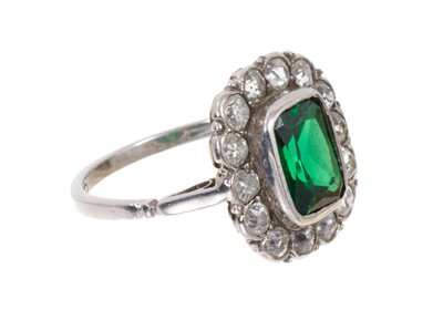 Lot 457 - 1920s diamond and green stone platinum ring