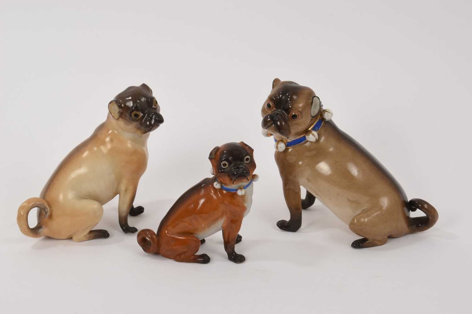 Lot 125 - Meissen pug and two similar pugs