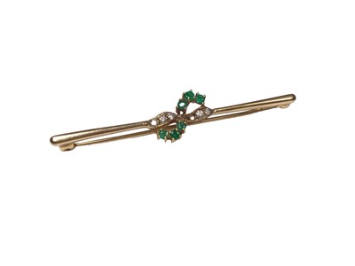 Lot 313 - Emerald and diamond brooch with a cross-over design in 9ct gold setting