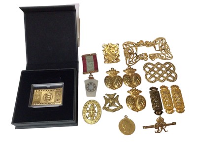 Lot 323 - Masonic medal with 9ct gold mounts, Guernsey Bailiwick gold stamp, gilded one shilling coin pendant and some other gilt badges and buckles etc