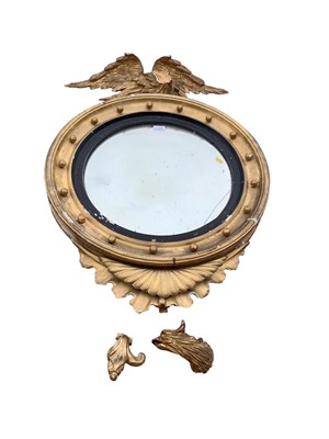 Lot 1208 - 19th century convex wall mirror in gilt wood frame with ebonised slip and eagle surmount, approximately 110cm x 64cm