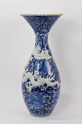 Lot 118 - Large late 19th century Japanese blue and white porcelain vase, moulded and painted in underglaze blue with dragons, shaped rim, 55cm high