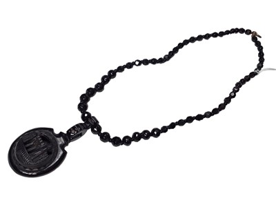Lot 37 - Victorian Whitby jet faceted bead necklace with a carved oval pendant depicting Whitby Abbey