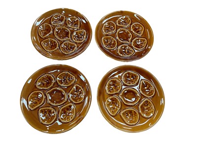 Lot 402 - Set of four French Niderviller pottery treacle glazed oyster plates, each 25cm in diameter (4).