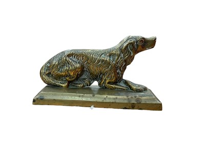 Lot 404 - 19th century brass fairing in the form of a seated spaniel, 14cm in overall length.