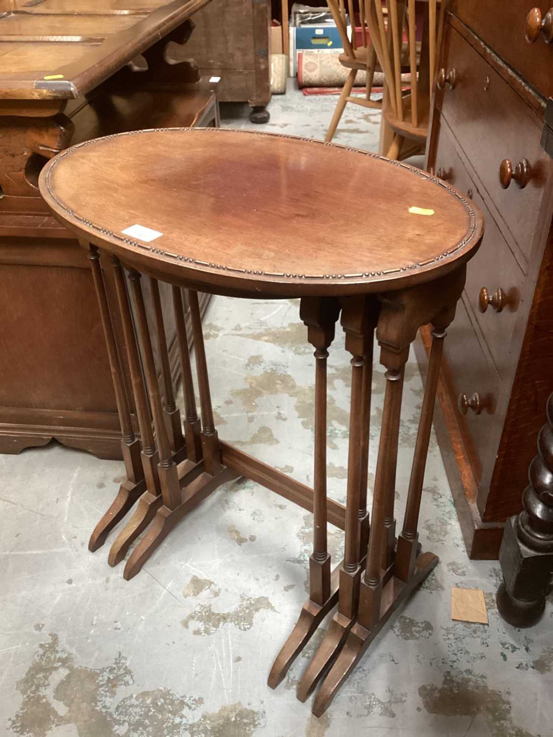 Lot 1341 - Edwardian mahogany nest three oval coffee tables on colomn supports