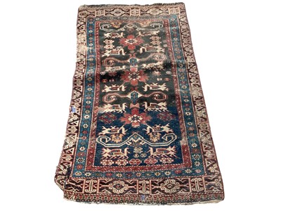 Lot 1395 - Eastern rug with geometric decoration on red, blue and black ground, 135cm x 72cm