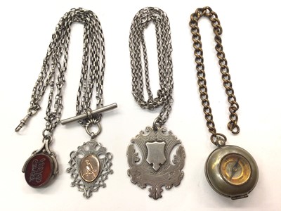 Lot 1048 - White metal triple row watch chain with two silver fobs, another silver fob on chain and a plated sovereign case/compass fob on brass chain