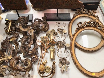 Lot 304 - Group of decorative gilt metal mounts, wall mounted hooks etc, pair of oval gilt frames and two carved wood fragments on display stands