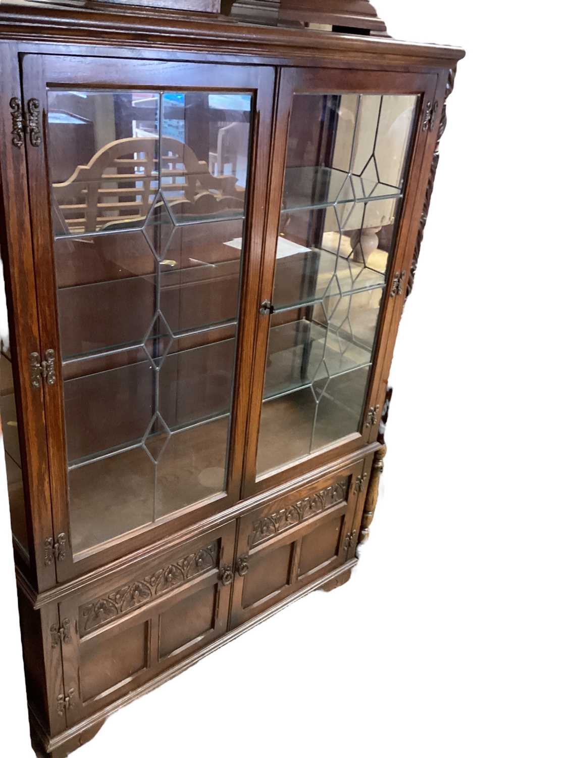 Lot 1408 - Old Charm oak display cabinet with glass shelves enclosed by two leaded glazed doors, and two carved panelled doors below, 107cm wide, 38cm deep, 161cm high