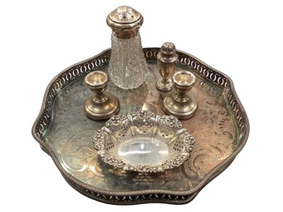 Lot 1075 - Pierced silver bon bon dish, pair of small silver candlesticks, silver pepper and a silver topped glass castor, together with a silver plated tray