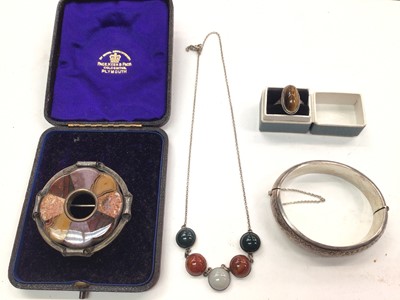 Lot 1099 - Silver and hard stone cabochon necklace, Scottish hard stone brooch, silver tiger's eye ring and a white metal bangle