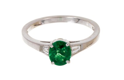 Lot 538 - Green diopside and diamond ring with an oval green diopside measuring approximately 6.8 x 5.6mm flanked by tapered baguette cut diamonds to the shoulders on platinum shank, ring size N½.