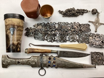 Lot 1115 - Silver plated panelled belt, tribal pendant on chain, silver mounted horn beaker, jambiya knife, one other knife and sundries