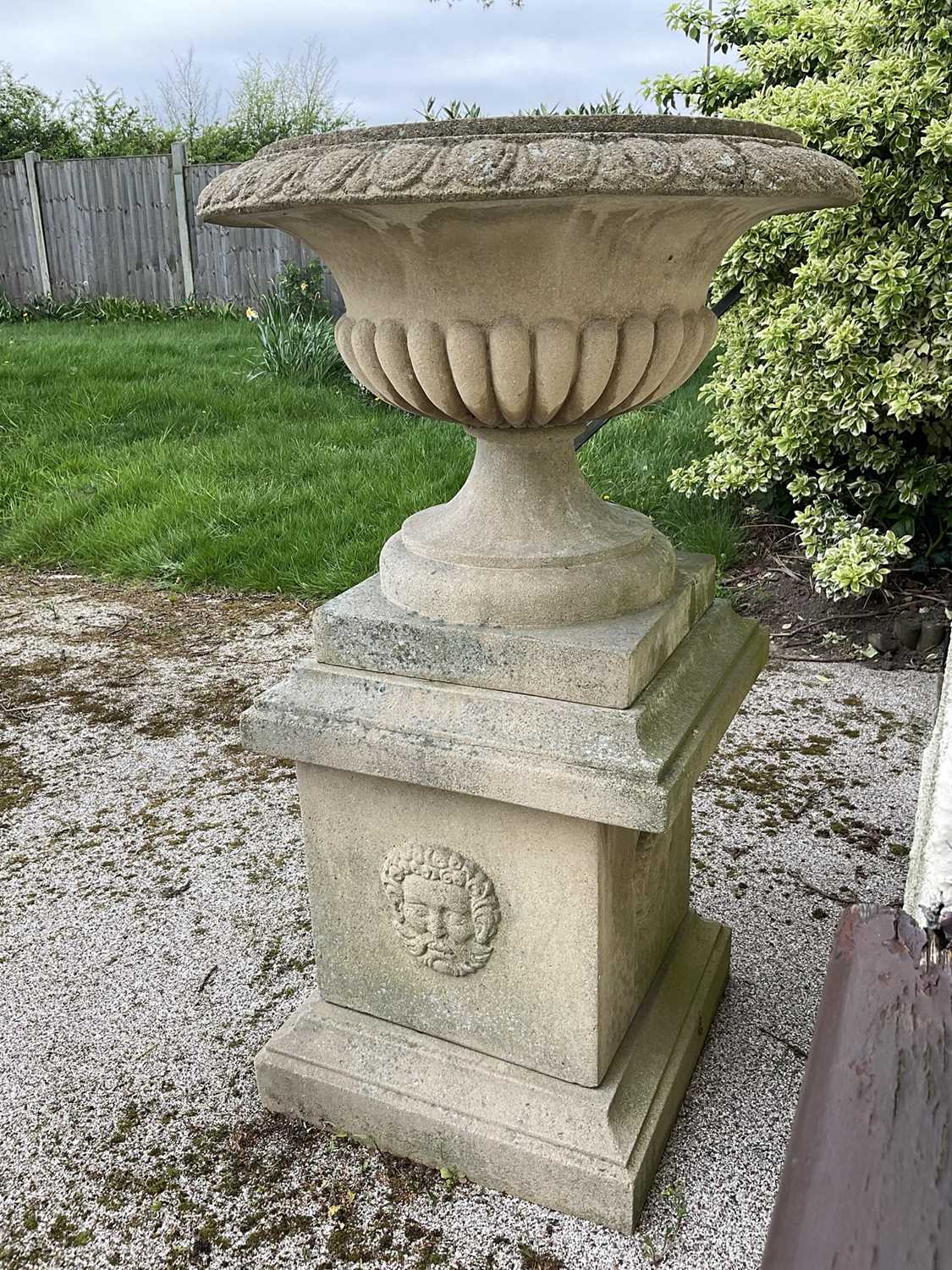 Lot 1550 - Large pair of reconstituted stone garden urms of campagna form with egg and dart rim, reeded bowl on socle bases with square plinths, 122cm high x 72cm diameter