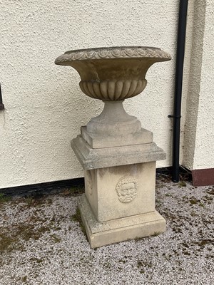 Lot 1550 - Large pair of reconstituted stone garden urms of campagna form with egg and dart rim, reeded bowl on socle bases with square plinths, 122cm high x 72cm diameter