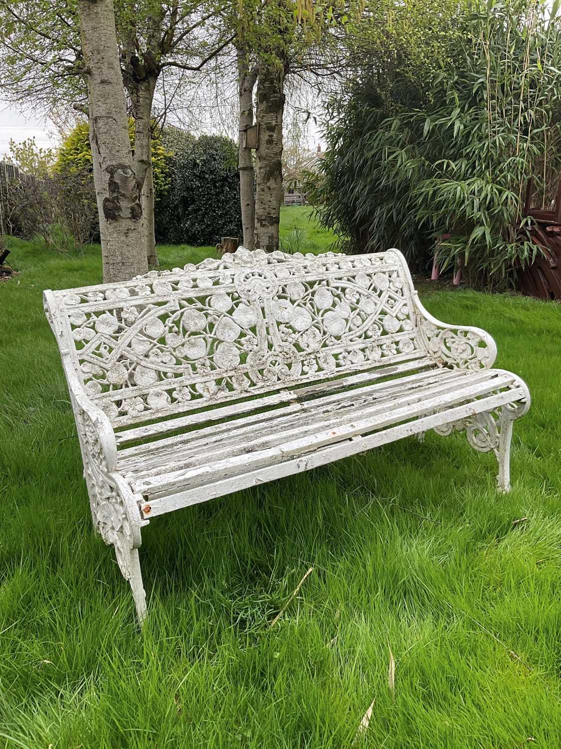 Lot 1556 - Victorian style white painted cast metal garden bench with lily pad and foliate design, 131cm wide.