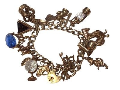 Lot 9 - 9ct gold flat curb link charm bracelet with eighteen 9ct gold novelty charms and a padlock clasp