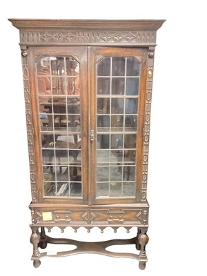 Lot 1364 - Early 20th century oak display cabinet, enclosed by two glazed doors, over two drawers with shaped stretcher below