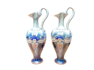 Lot 1142 - Pair of Royal Doulton stoneware ewers with stylised floral decoration on blue and green ground, 29.5cm high