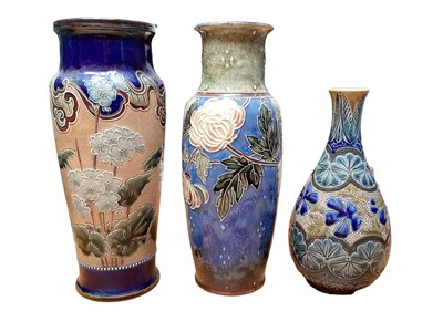 Lot 1143 - Two Royal Doulton stoneware vases with floral decoration, 29.5cm high, and one other, 23.5cm high