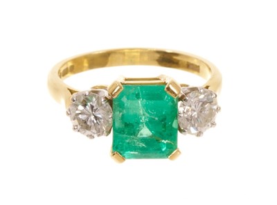 Lot 542 - Emerald and diamond three stone ring with a rectangular step cut emerald measuring approximately 8.3mm x 7mm x 5.8mm, flanked by two brilliant cut diamonds in claw setting on 18ct yellow gold shank...