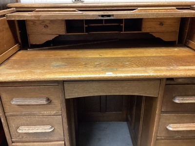 Lot 1330 - 1920s light oak twin pedestal roll-top desk enclosed by tambour shutter with six drawers and a 1920s light oak desk chair (2)