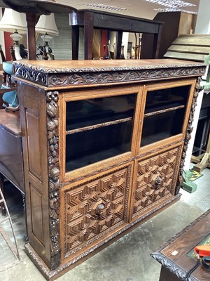 Lot 1274 - Late Victorian heavily carved oak bookcase with two glazed doors and two geometric panelled doors below, 150cm wide, 37cm deep, 134cm high