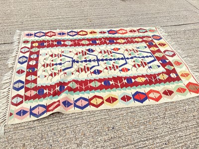 Lot 1413 - Kilim rug with geometric decoration on cream, blue, red and green ground, 190cm x 132cm