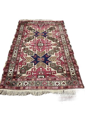 Lot 1420 - Eastern rug with geometric decoration on red, blue and green ground, 222cm x 140cm