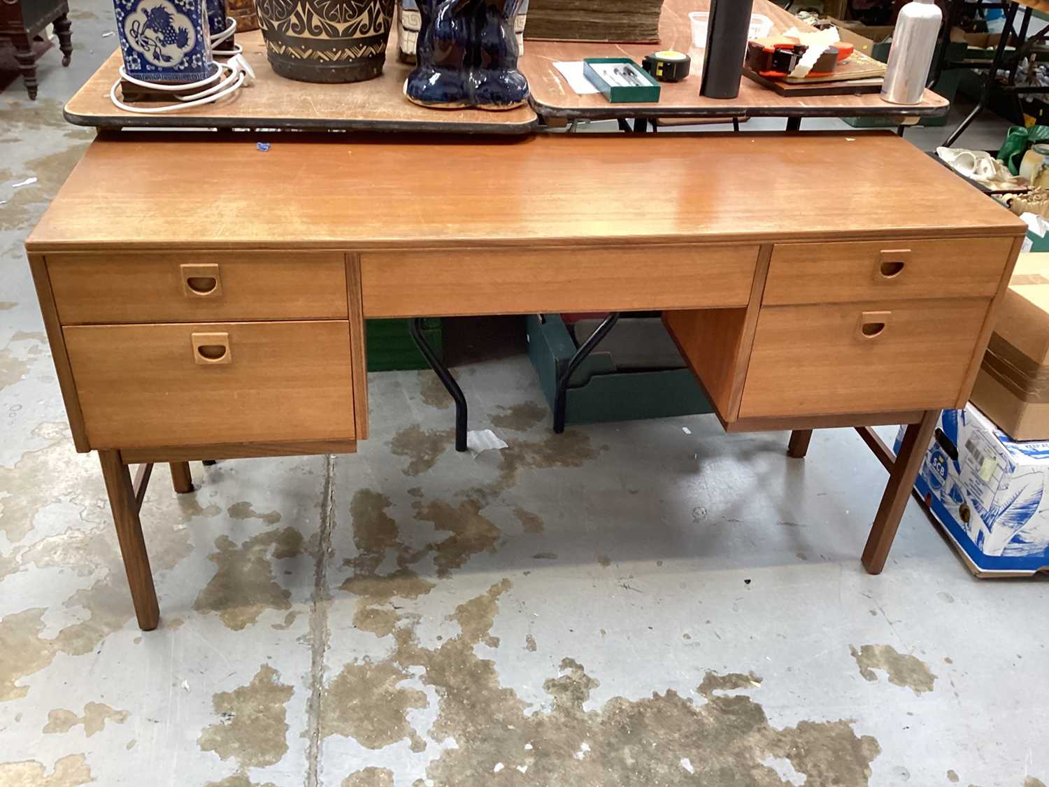 Lot 1444 - Mid century teak five drawer kneehole desk/dressing table, bearing label Alfred Cox Furniture, 137cm wide, 44cm deep, 72cm high