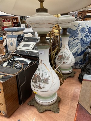 Lot 498 - Pair of white glass table lamps with transfer printed scenes and metal mounts, together with another lamp.