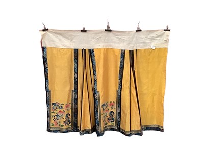 Lot 2121 - Chinese yellow silk brocade skirt with embroidered bands and applique symbols.