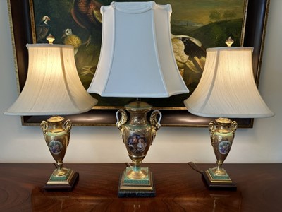 Lot 1191 - Garniture of three Vienna style porcelain table lamps with shades, the largest 74cm high