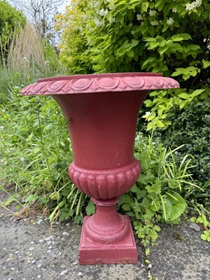 Lot 1215 - Pair of cast iron campana form urns, red painted, 61cm high