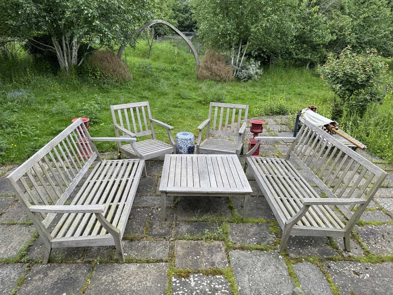 Lot 1223 - Suite of teak garden furniture comprising a pair of low wooden benches and en-suite chairs with square coffee table (5), with removable cushions