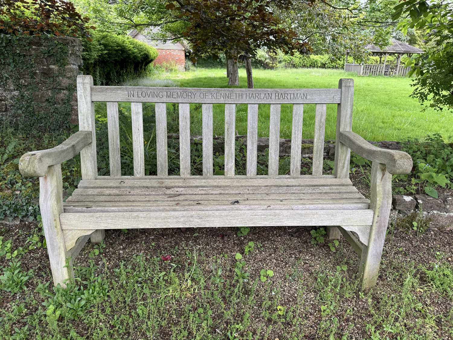 Lot 1219 - Pair of teak garden benches with engraved