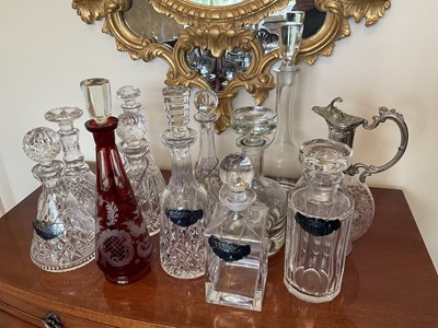 Lot 318 - A good collection of twelve glass decanters and stoppers, to include examples by Waterford, Stuart and Tiffany & Co, some with plated wine labels