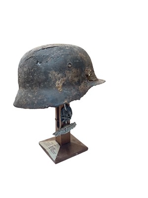 Lot 756 - Second World War Nazi Wehrmacht M35 pattern helmet in relic condition on stand, together with two award badges.