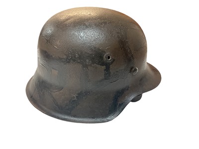 Lot 757 - Second World War Nazi Wehrmacht M35 pattern helmet in camouflage painted finish with leather liner and chin strap, stamped under rear of brim (indistinct).