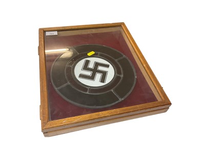 Lot 763 - Second World War Nazi Swastika stained glass panel, measuring 26cm in diameter, presented in a glazed cabinet.